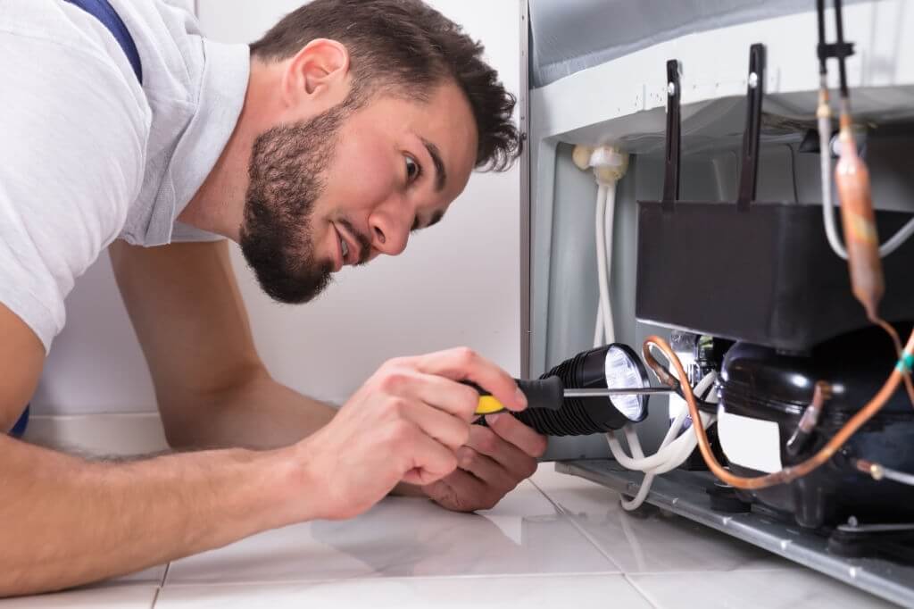 technician fixing the refrigerator